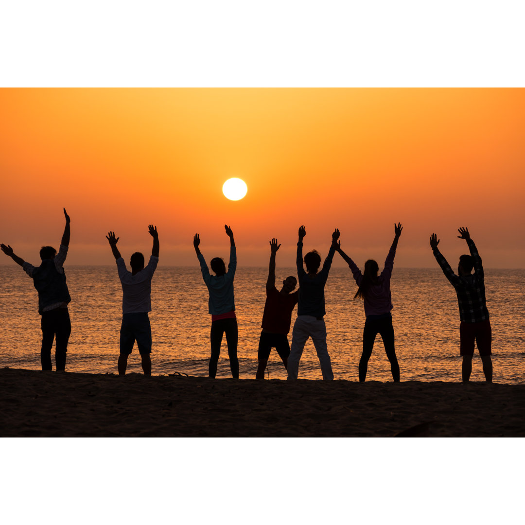 Eine Gruppe von Menschen trainiert am Strand