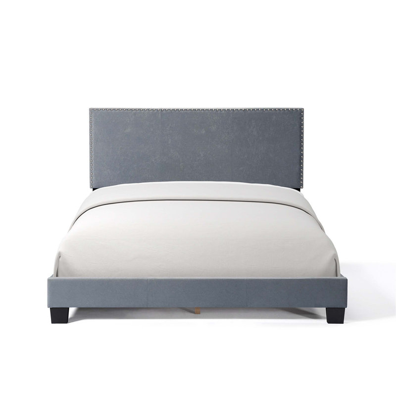 Luxueux lit plateforme tapissier en velours avec garniture cloutée et structure en bois robuste, idéal pour les chambres élégantes et confortables.
