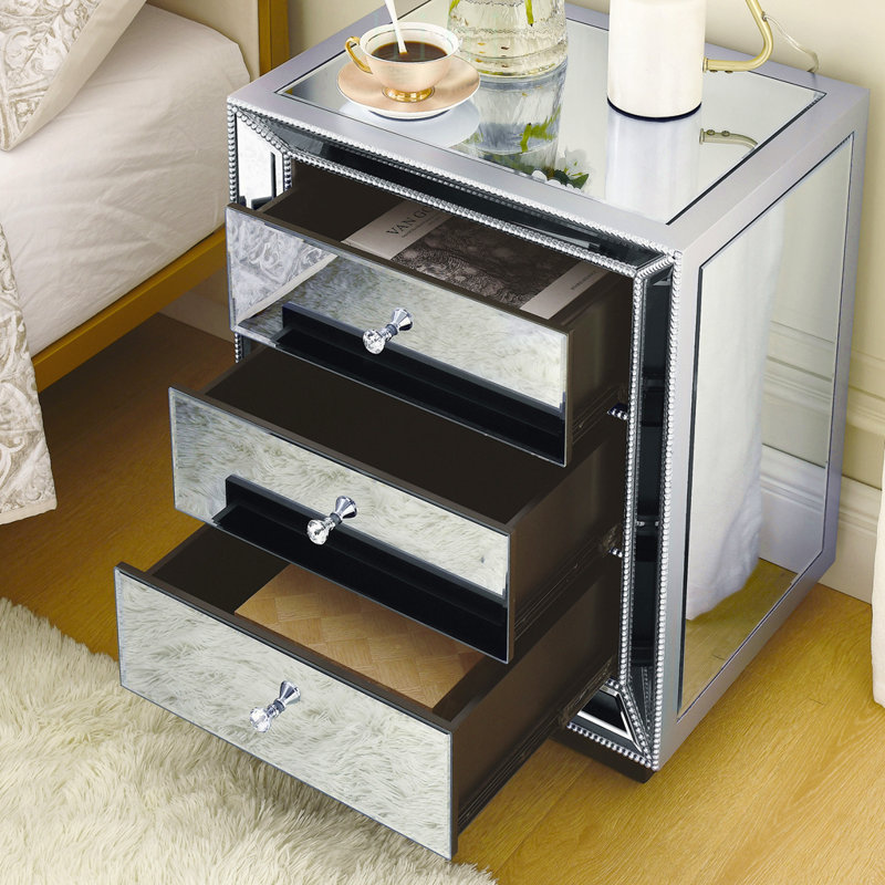 Meuble à trois tiroirs avec fini miroir perlé, idéal pour un rangement élégant et une utilisation multifonctionnelle dans les maisons modernes.