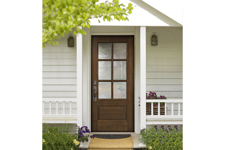 Brown wood front door and a white front porch.