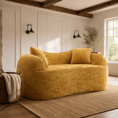 Yellow curved two - person compress  sofa. It has armrests on both sides, comes with two pillows, is suitable for small - sized apartments, and can be placed in the living room or bedroom.