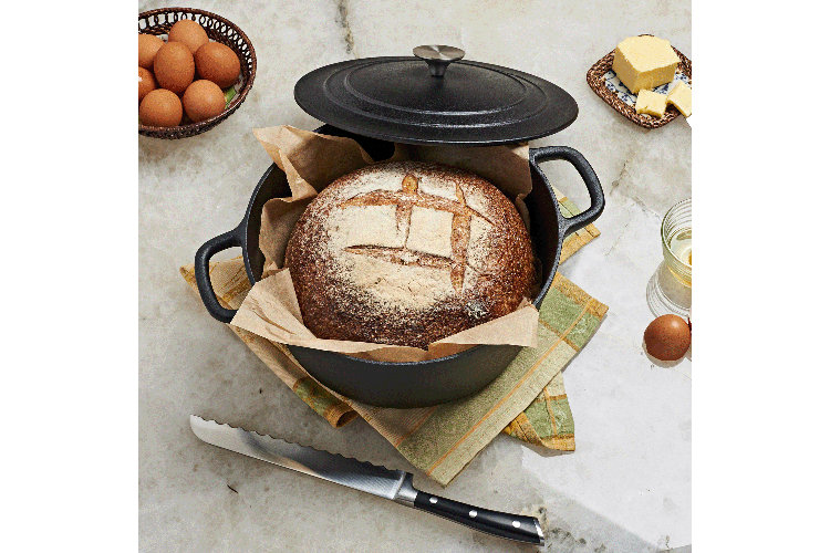 cast iron dutch oven with a home baked bread inside