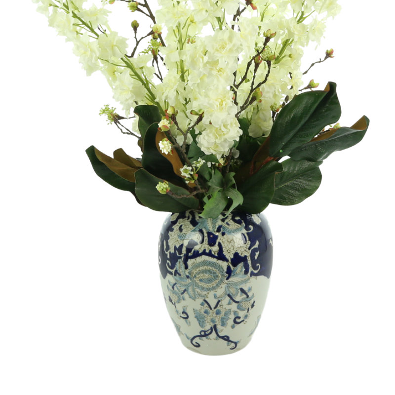 Delphinium And Magnolia Leaves In Ceramic Vase