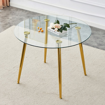 Un plateau de table en verre d'un diamètre de 40 po et une table de salle à manger moderne minimaliste avec pieds en métal plaqué or