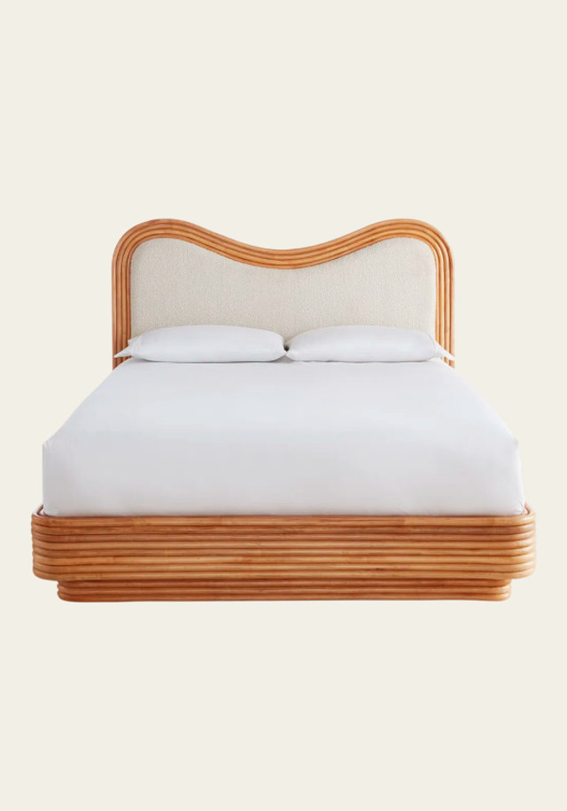 Rattan platform bed with upholstered headboard.