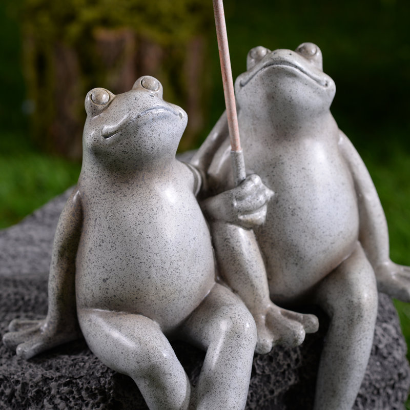 Statue de jardin assis avec quelques grenouilles et parasol