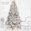 Sapin de Noël artificiel floqué avec éclairage intégré et pommes de pin naturelles pour une décoration festive de Noël.