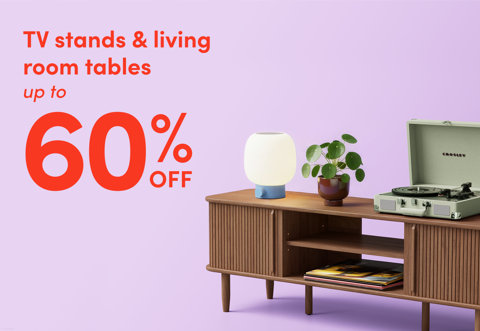 TV stands and living room tables up to 60 percent off featuring a mid-century modern wooden media console topped with a lamp, a potted plant, and a vintage-style record player.