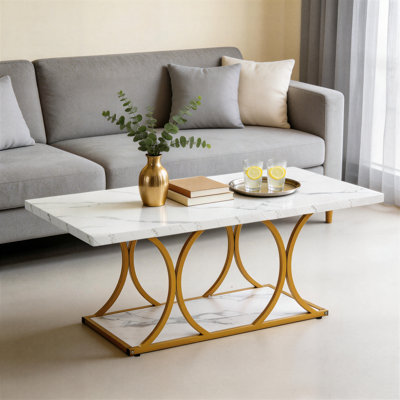 Cette table basse blanche et moderne en faux marbre présente un design rectangulaire à double couche avec des pieds géométriques et une structure en métal simple et robuste. Convient aux salons et aux bureaux, il est facile à assembler.