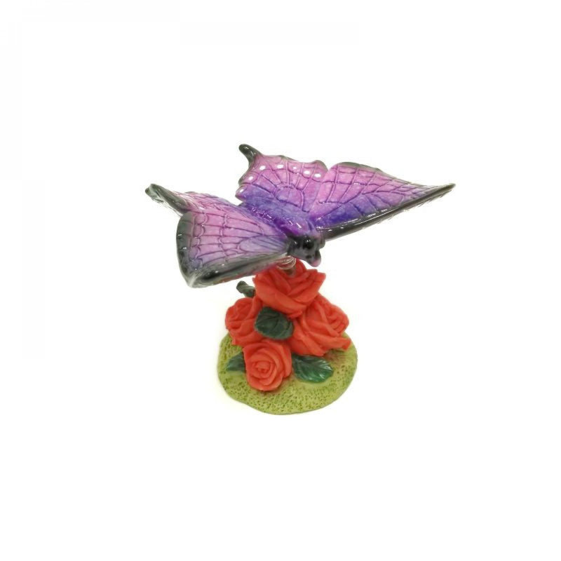 Figurine papillon mauve sur une fleur
