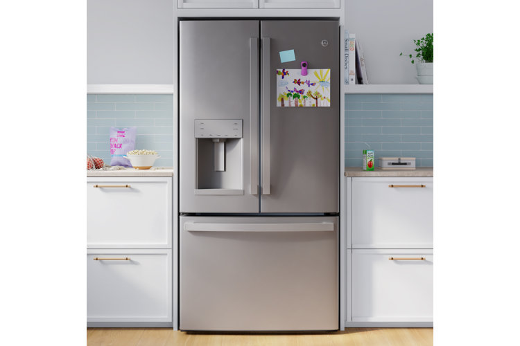 Kitchen with a stainless steel French door refrigerator with two half doors on top of a pull out freezer compartment.