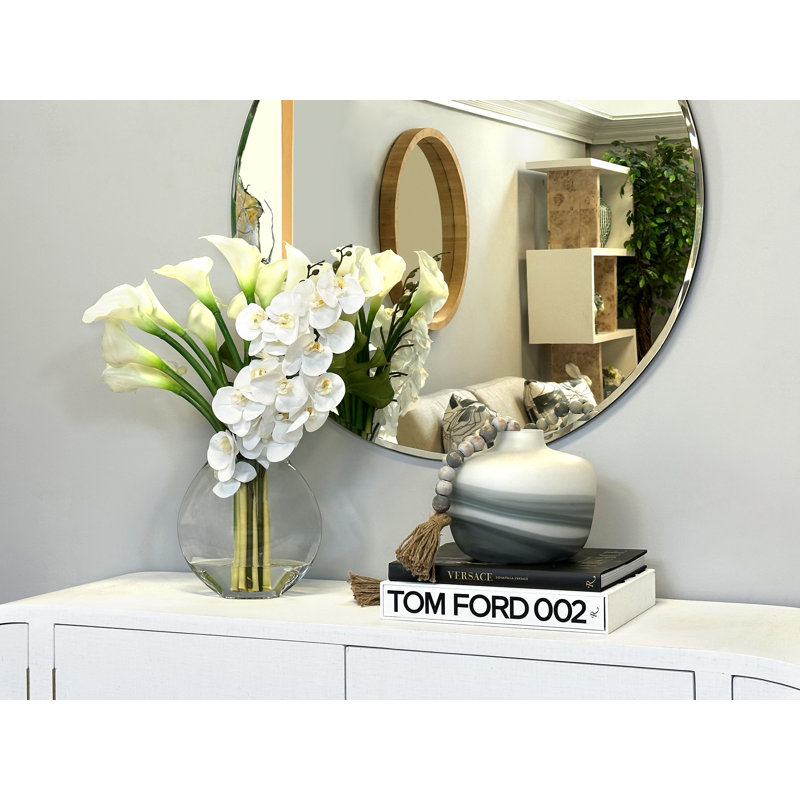 Orchids, Calla Lily And Philodendron Leaves Arranged In A Clear Circular Glass Vase