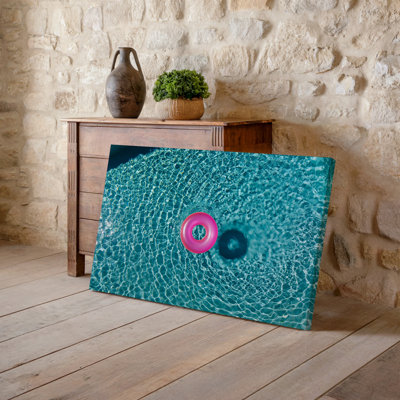 Toile, un flotteur de piscine gonflable rose vif repose sereinement sur la surface de l'art mural d'une piscine cristalline entourée d'art sur toile