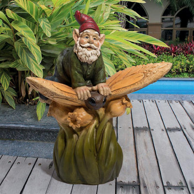Statue de gnome de jardin sur un dos de papillon