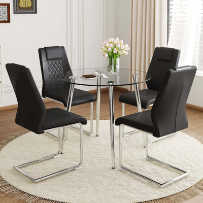 Une table ronde minimaliste moderne en verre trempé transparent avec des pieds en métal argenté et 4 chaises de salle à manger modernes en cuir d'unité centrale pour une expérience luxueuse.