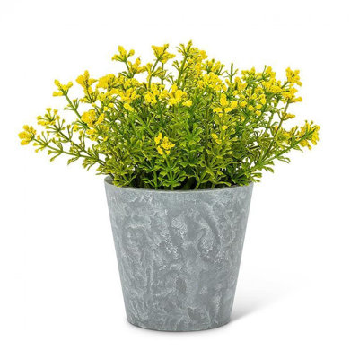 Floraison d'une plante jaune dans un pot de fleurs artificielles