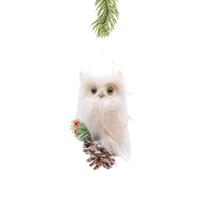Tissu blanc suspendu à un hibou sur une pomme de pin