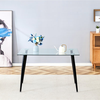 Table de salle à manger en verre transparent avec pieds dorés pour un intérieur moderne et élégant