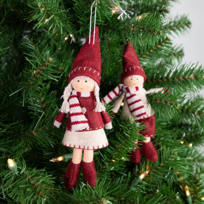 Garçon et fille suspendant des décorations de Noël pour poupée