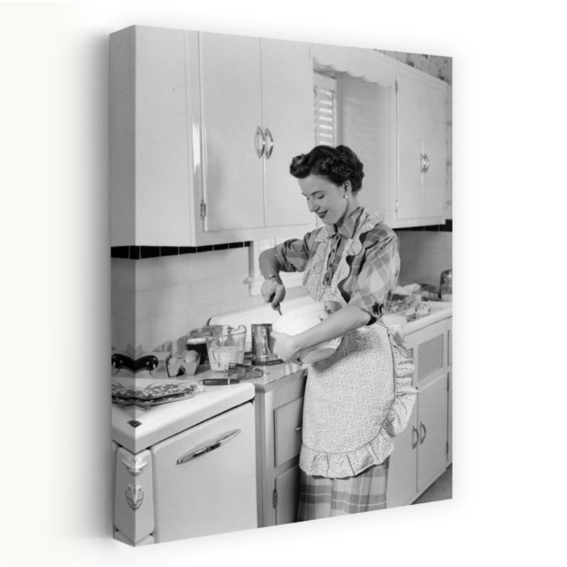 1950s WOMAN HOUSEWIFE IN KITCHEN APRON MIXING BAKING INGREDIENTS IN BOWL by H. Armstrong Roberts - Wrapped Canvas Print