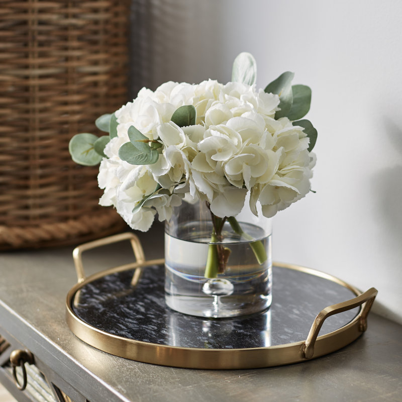 Ensemble d’hortensias blancs dans un vase cylindrique en verre