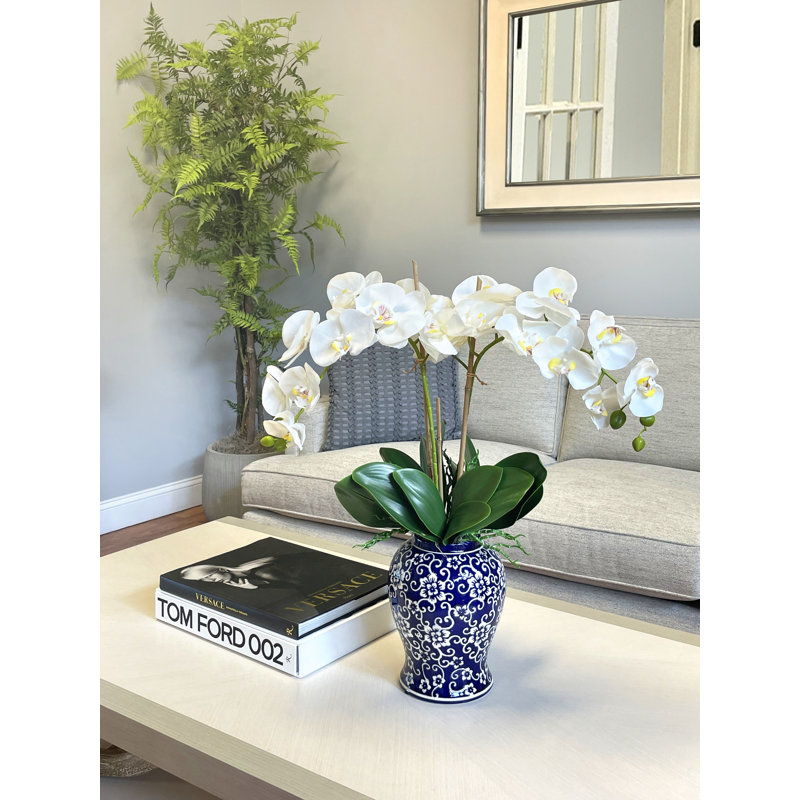 Orchid Arrangement In A Ceramic Vase With Leaves
