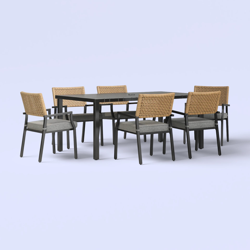Outdoor dining set with gray cushioned chairs and woven backs.