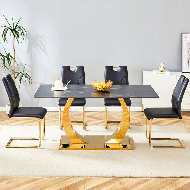 Plateau de table en pierre frittée et chaises noires. Pieds dorés. Pour la texture de la table. Décoration en acier inoxydable