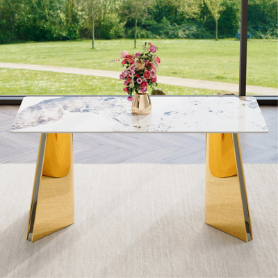 Table de salle à manger de 63 po x 31,5 po x 30 po en pierre frittée à motif Pandora avec pieds papillon en acier inoxydable doré. Le plateau de table est conçu pour être résistant aux rayures et à la chaleur