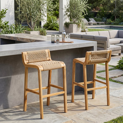 Ensemble de 2 tabourets de bar intérieur / extérieur en teck clair Blume avec dossier bas en rotin synthétique tissé à la main