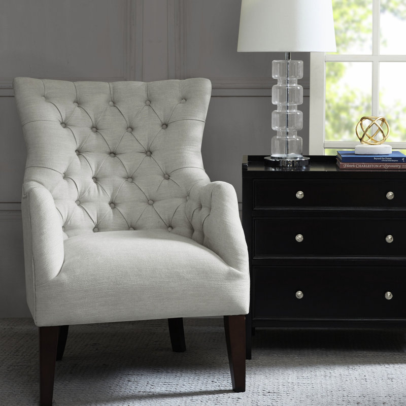 Fauteuil à oreilles avec détails en bois massif et boutons, structure en mousse haute densité à finition pied de bouleau