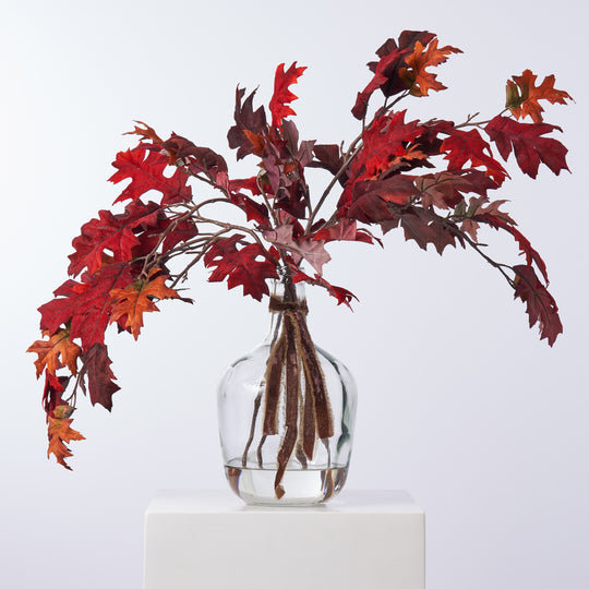 Branches de feuilles de chêne en velours rouge bourgogne d'automne réalistes dans un vase en verre
