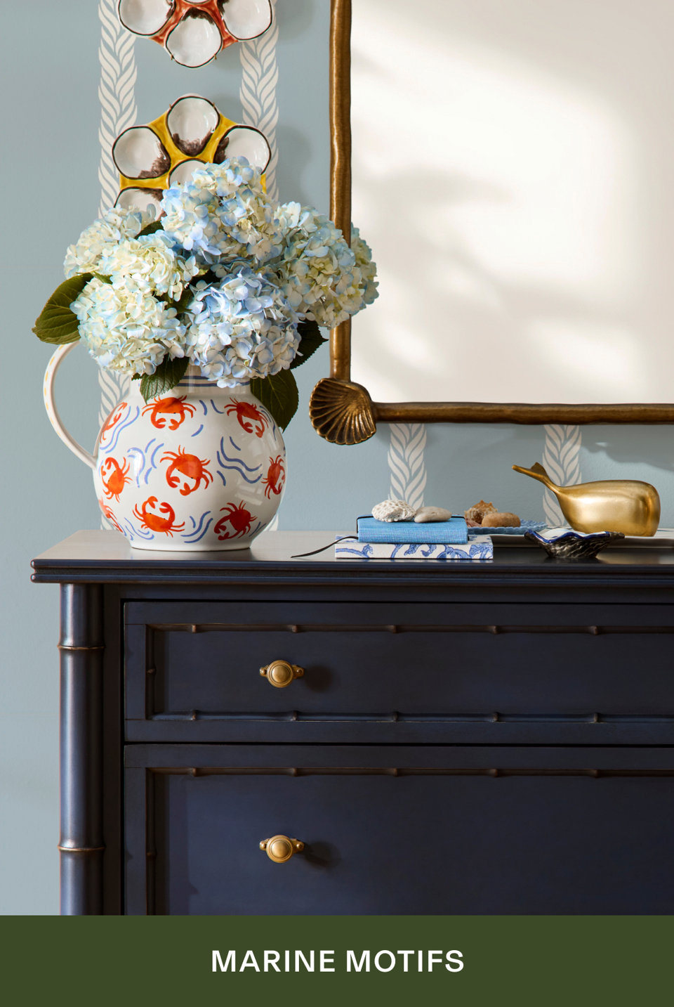 Marine Motifs - navy dresser with crab-patterned pitcher filled with hydrangeas and coastal decor