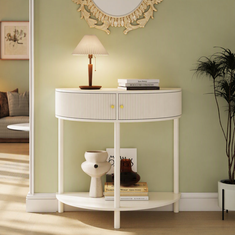 Cette console demi-lune conserve sa silhouette classique en demi-lune, désormais sublimée par des façades de tiroirs ornées d'un motif ondulé en 3D, réalisé artisanalement. La texture semi-circulaire ondulée apporte profondeur et raffinement tactile.