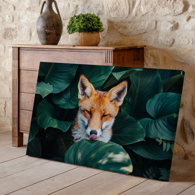 Toile, gros plan sur un renard ludique niché parmi de grandes feuilles vertes luxuriantes avec ses yeux doucement fermés et parfaites pour une impression sur toile