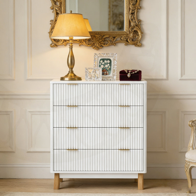 Commode moderne à 4 tiroirs avec façades cannelées et poignées dorées pour un rangement élégant dans la chambre à coucher.