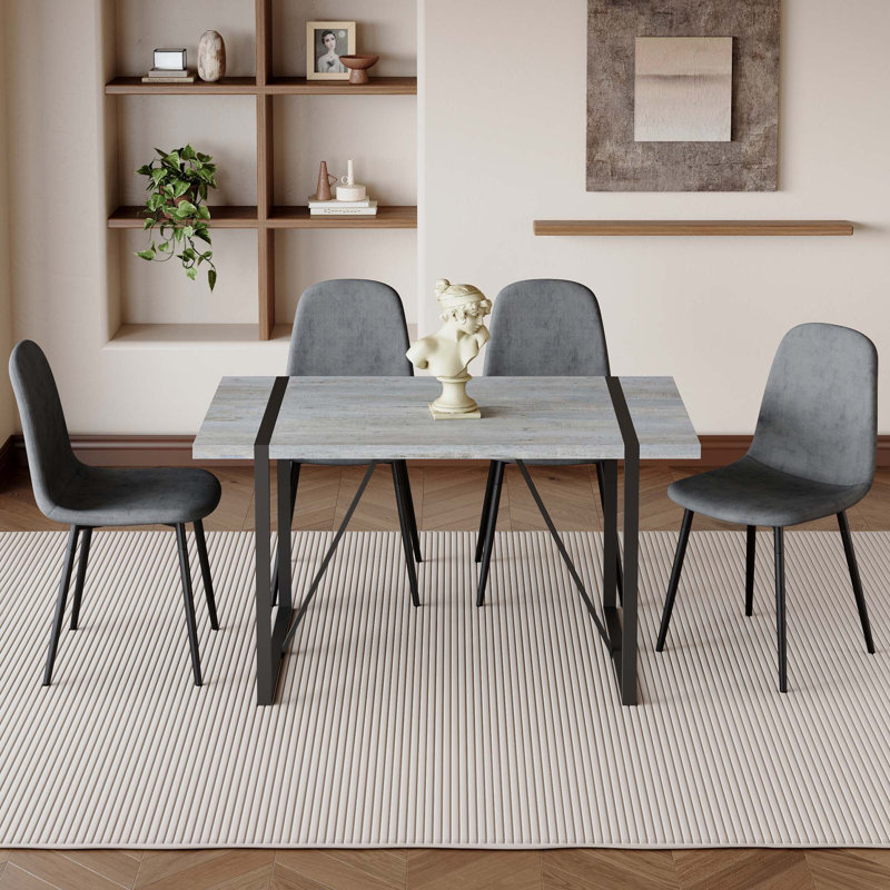 Ensemble de table et de chaises. Une table de salle à manger rectangulaire rétro minimaliste avec un dessus spécialement texturé et des pieds en métal, jumelée à 4 chaises