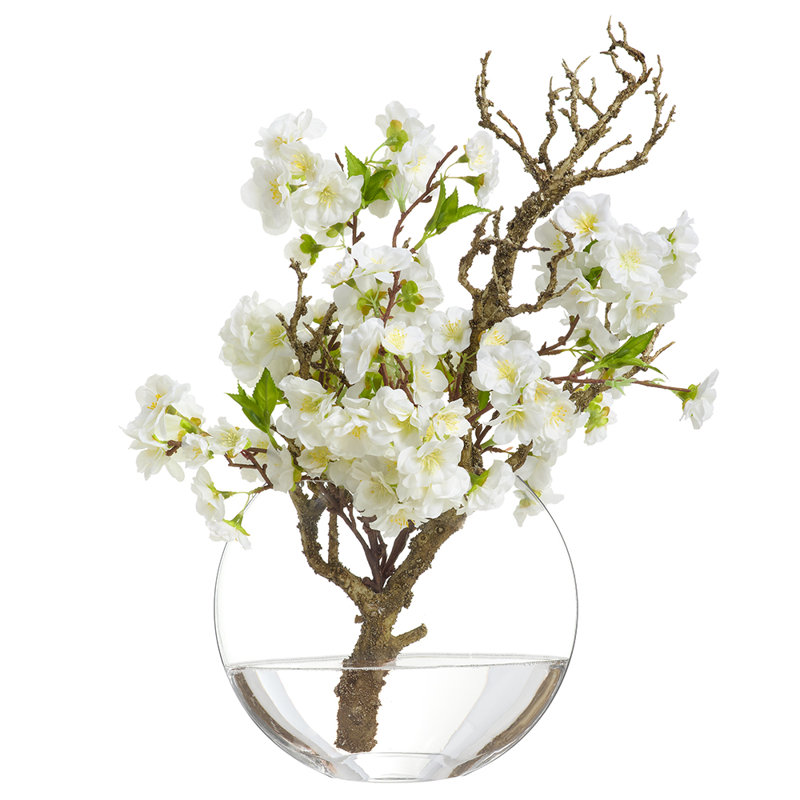 Branche de cerisier en fleurs dans un vase en verre blanc
