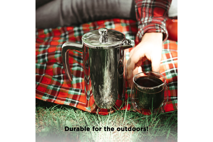metal french press on plaid blanket with mug
