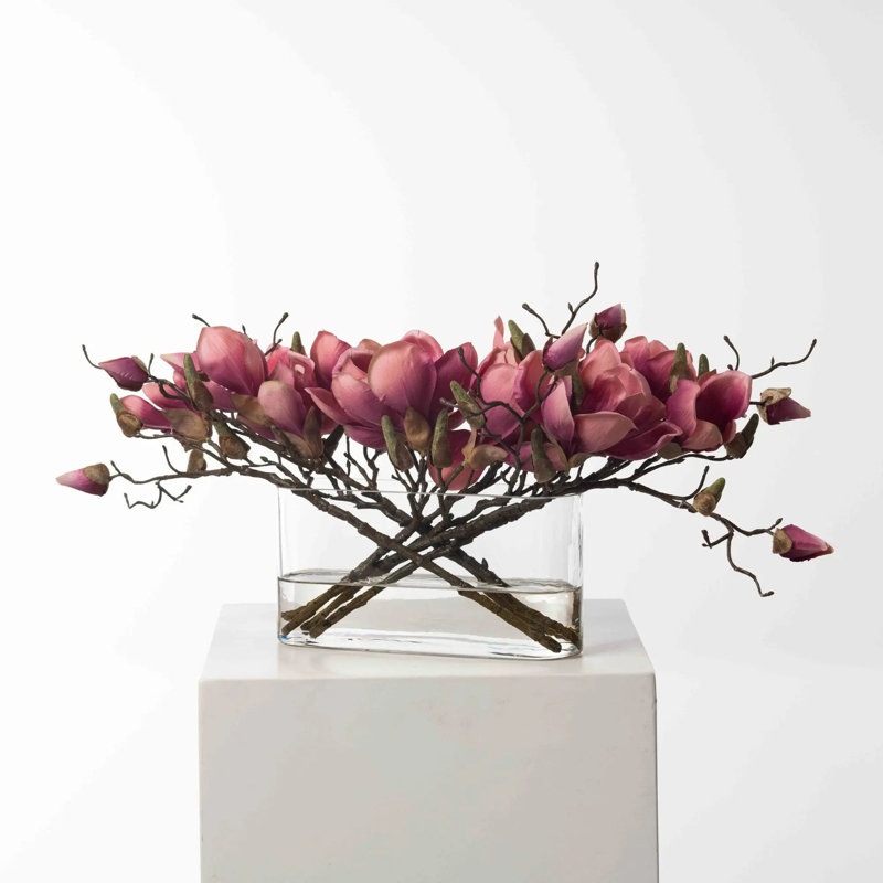Branche de magnolia fuchsia dans un vase de poche ovale