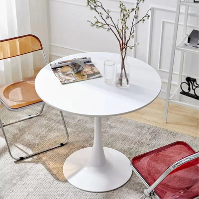Table ronde blanche avec piètement en acier massif pour un usage quotidien dans un salon moderne et stable