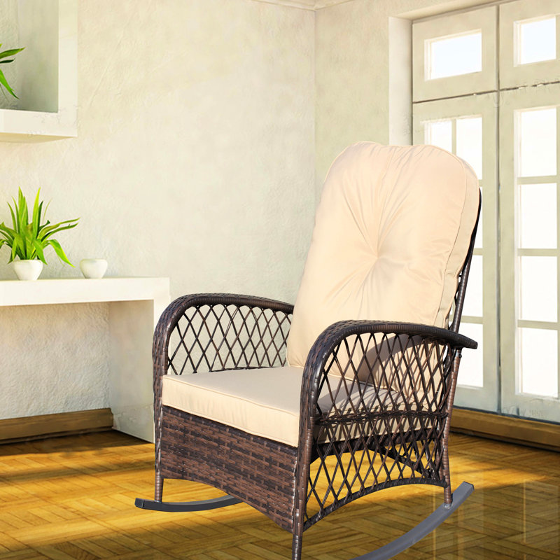 Fauteuil à bascule d'extérieur, modèle spacieux avec accoudoirs, structure robuste en acier, idéal pour terrasse, jardin ou cour arrière. Chaise basse brune avec coussin, protégée et adaptée à une utilisation extérieure.
