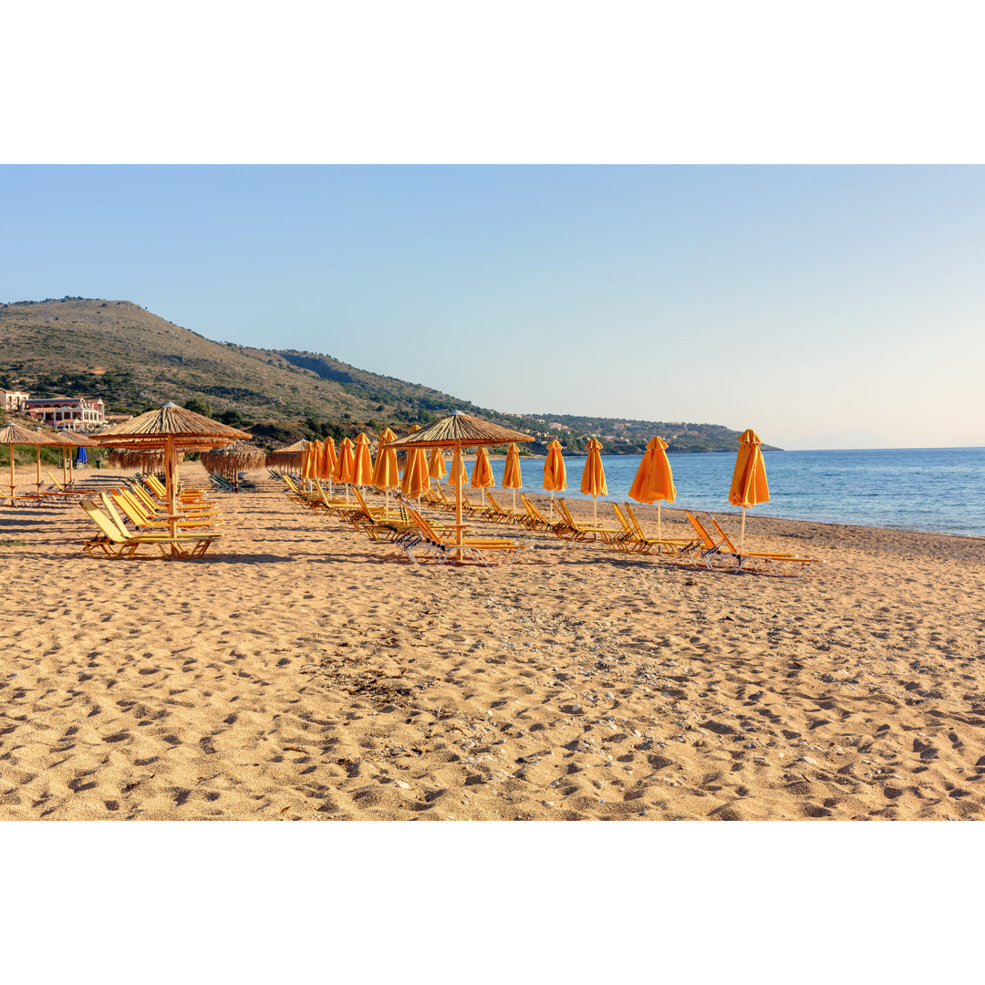 Orangefarbene Sonnenschirme am Strand von Skala