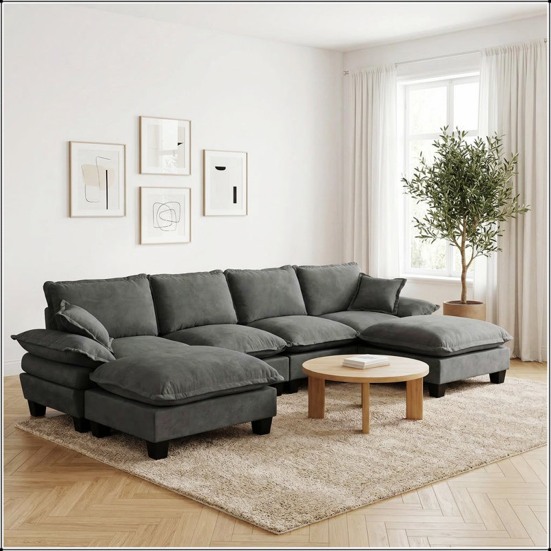 Canapé d'angle modulaire en forme de U avec motif de voilier et poufs amovibles pour un agencement confortable dans le salon.