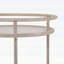 Chariot-bar rond avec tablettes en verre trempé et accents dorés, finition blanche vieillie pour une élégance moderne